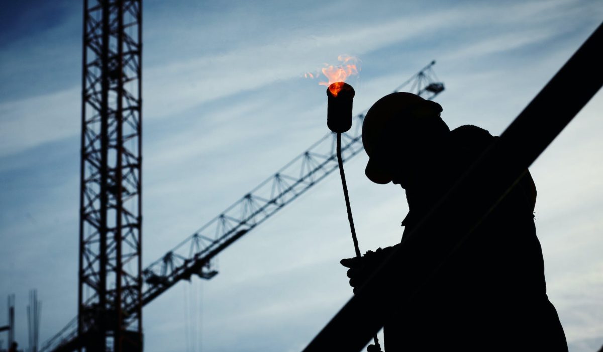 silhouette of man holding flamethrower